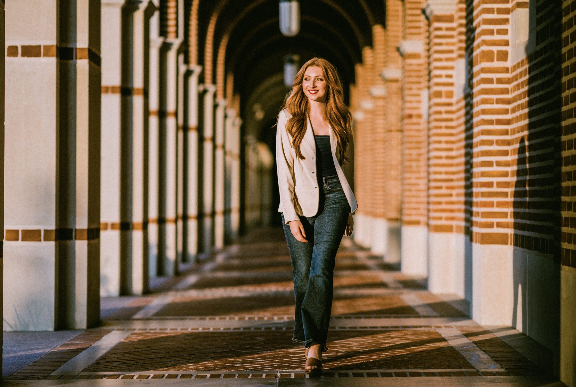 Savannah Walker walking through a brick archway